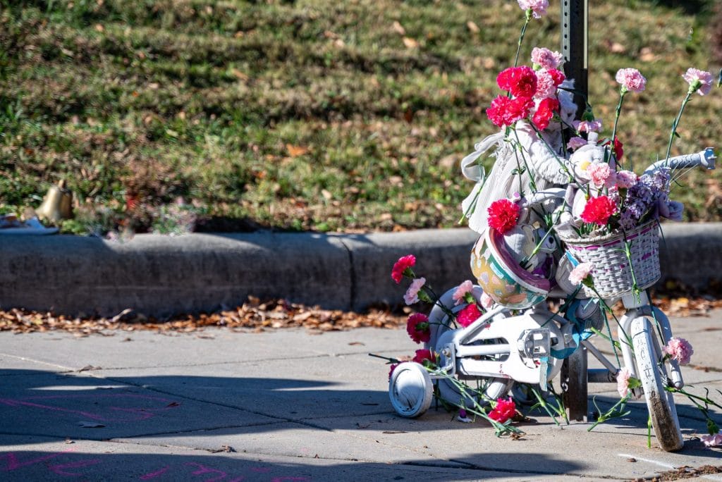 A child's ghost bike, covered in flowers