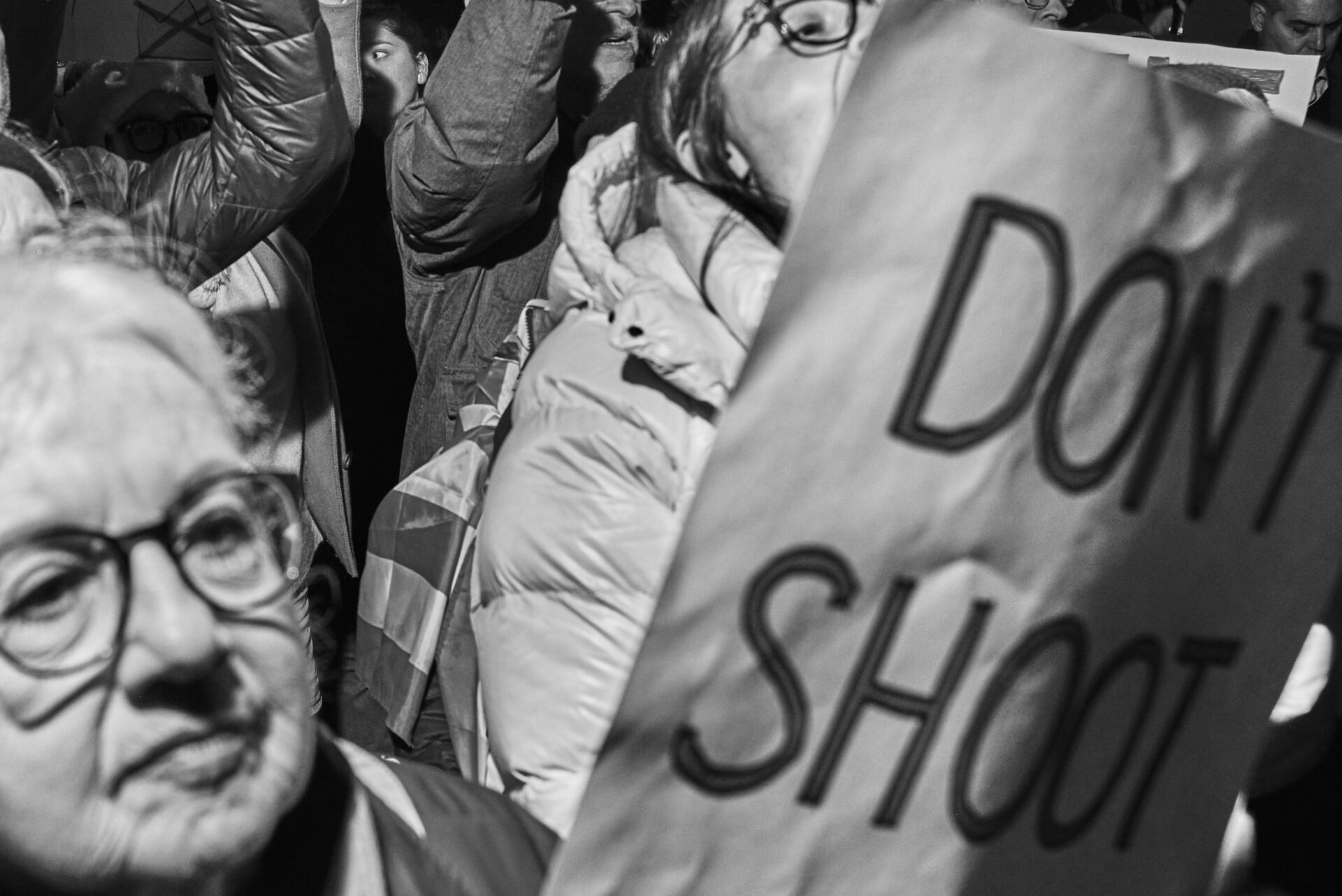 A group of protestors, one holds a sign that says "Don't Shoot"