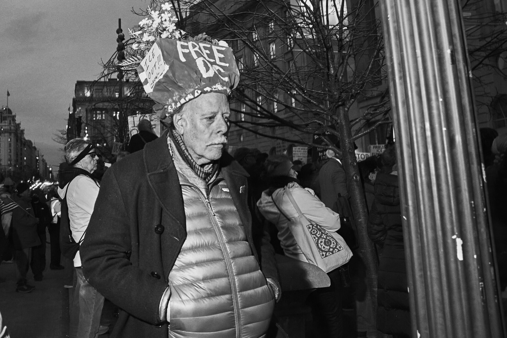 A man wearing a paper hat adorned with flowers that reads "Free DC"