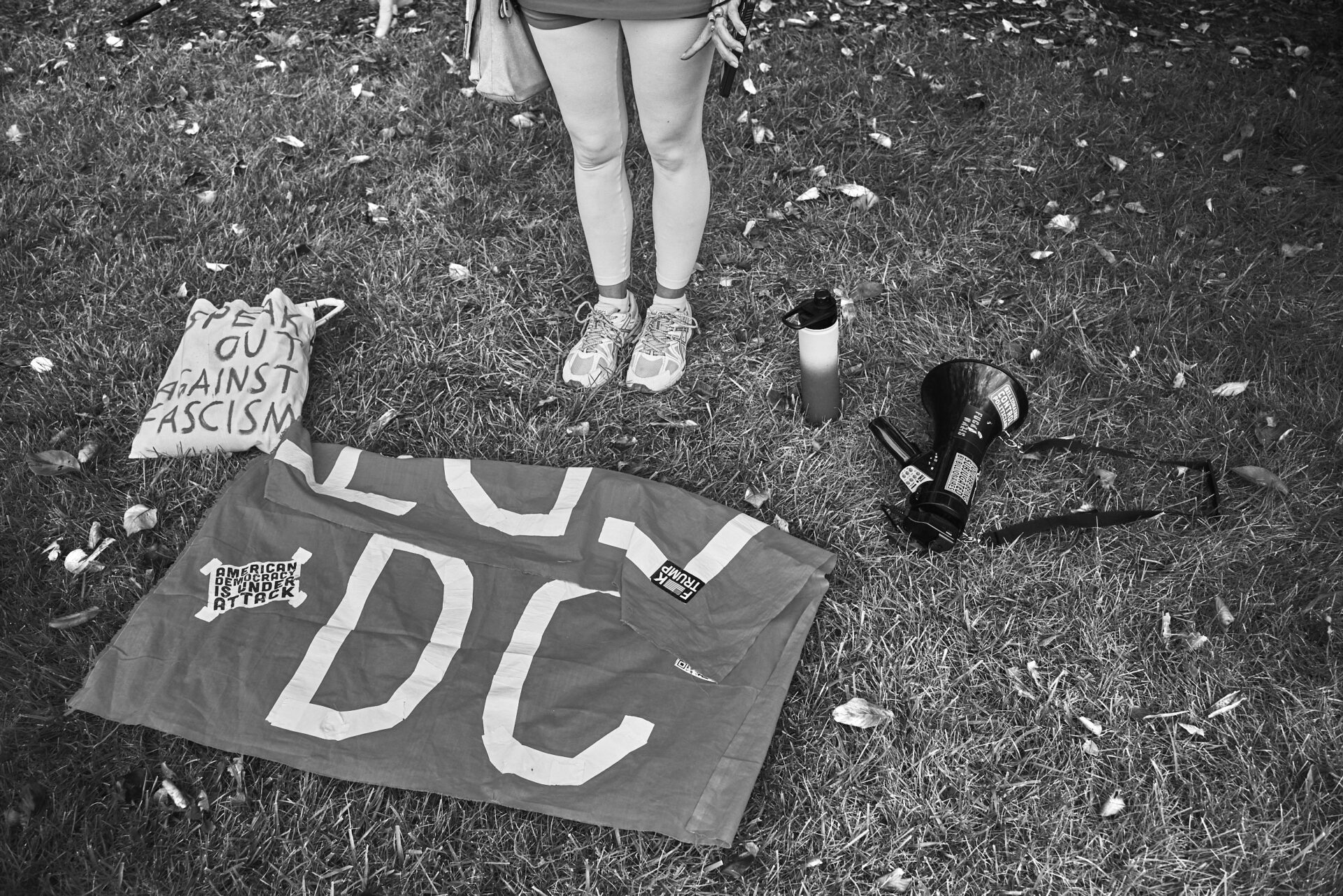 A pair of legs standing in front of a flag that says "DC"